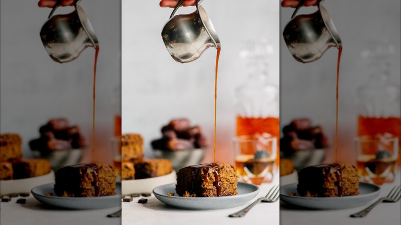 Person drizzling whiskey syrup on cake