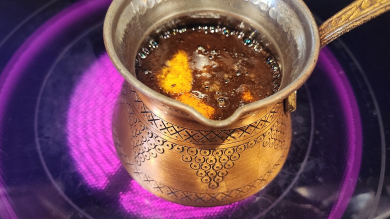 Turkish coffee brewing with lemon peel