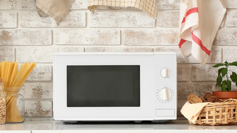 Microwave in elegant modern kitchen with brick backsplash