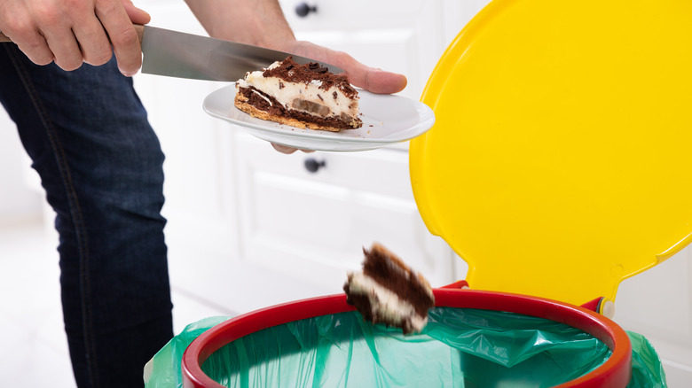 person throwing away cake