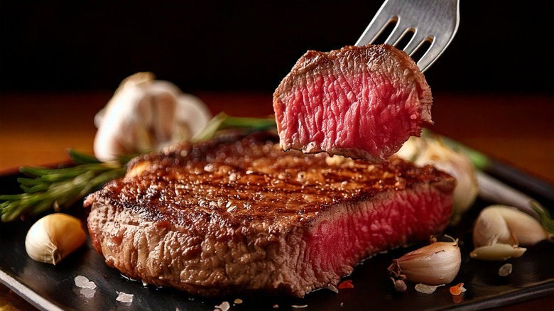 Medium rare steak with garlic and rosemary