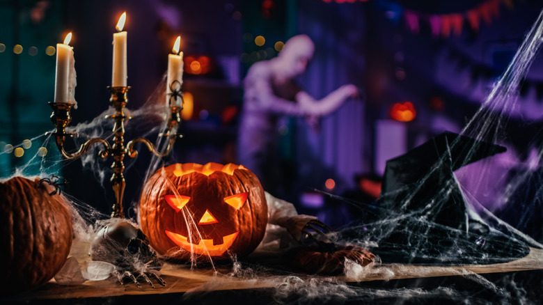 a table filled with an assortment of halloween decor with a mummy in the background