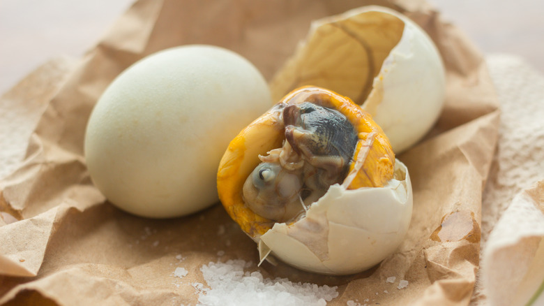 A whole and a half-peeled balut