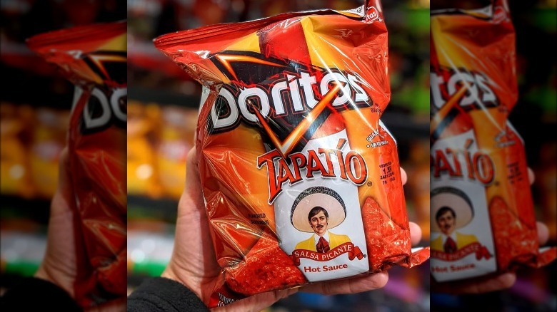 Person holding a bag of Tapatio Doritos