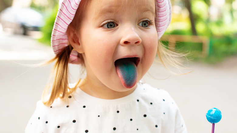 Child with artificial dye on tongue from eating lollipop