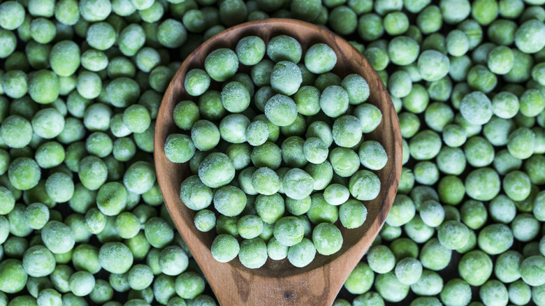 Frozen peas in wooden spoon