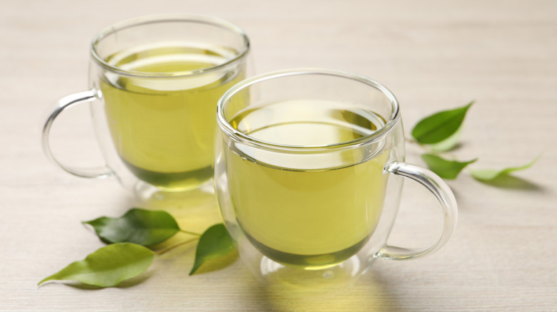 Two glass mugs of green tea