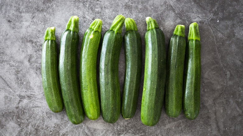 Row of zucchini on gray background