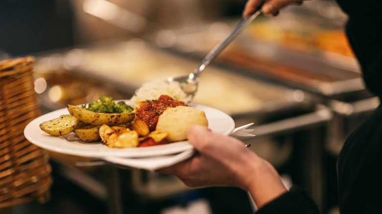 serving food on plate at buffet