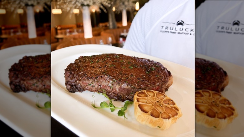 Truluck's waiter delivering steak 