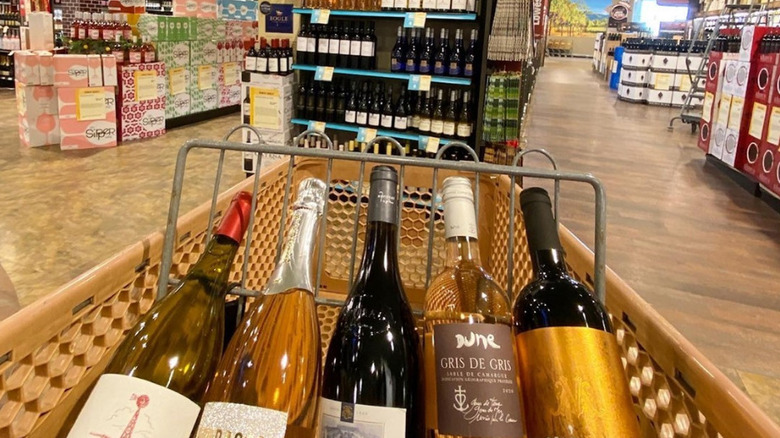 bottles of wine in a shopping cart in a large beverage store