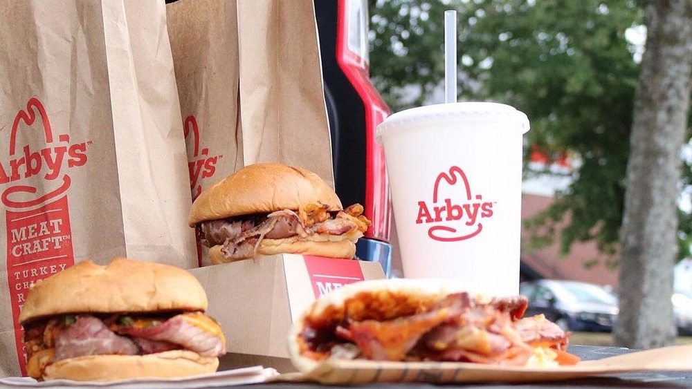 Three Arby's sandwiches and fountain drink