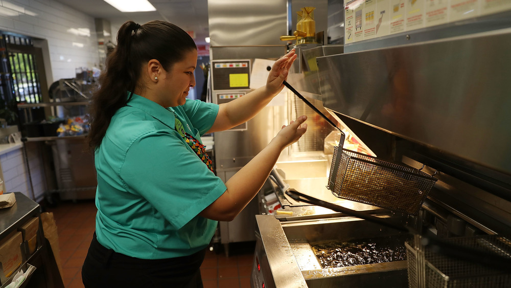 fast food worker making fries