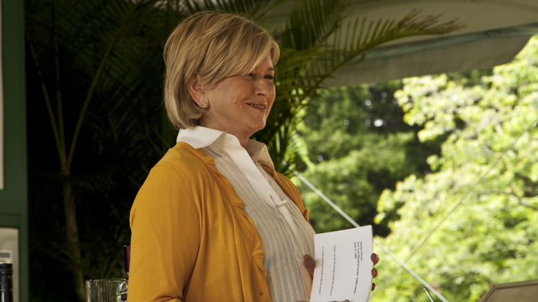 Martha Stewart in a yellow cardigan talking in a garden