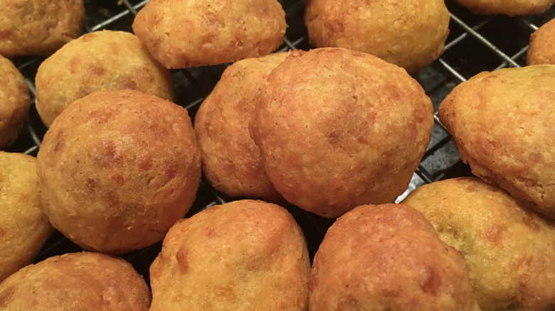 Olive cheese puffs piled on a cooling rack