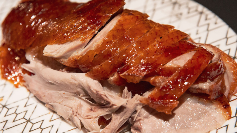 Sliced Peking duck on white and gold platter