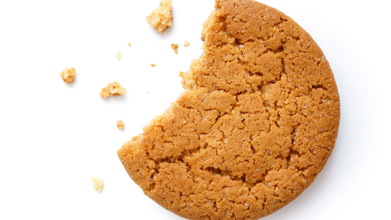 Half eaten ginger biscuit with crumbs