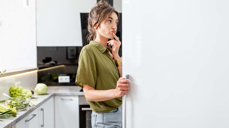 woman looking in her refrigerator