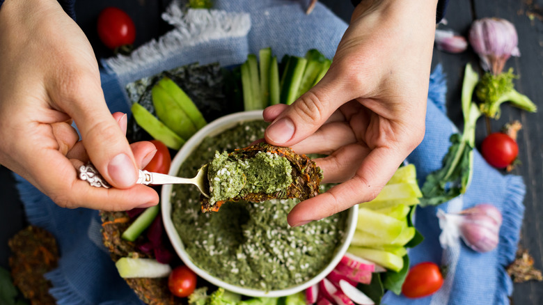 Person spooning out basil pesto spread