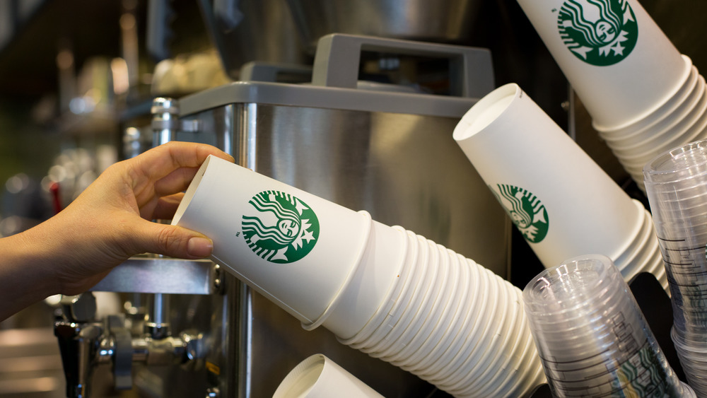 Hand grabbing a Starbucks cup