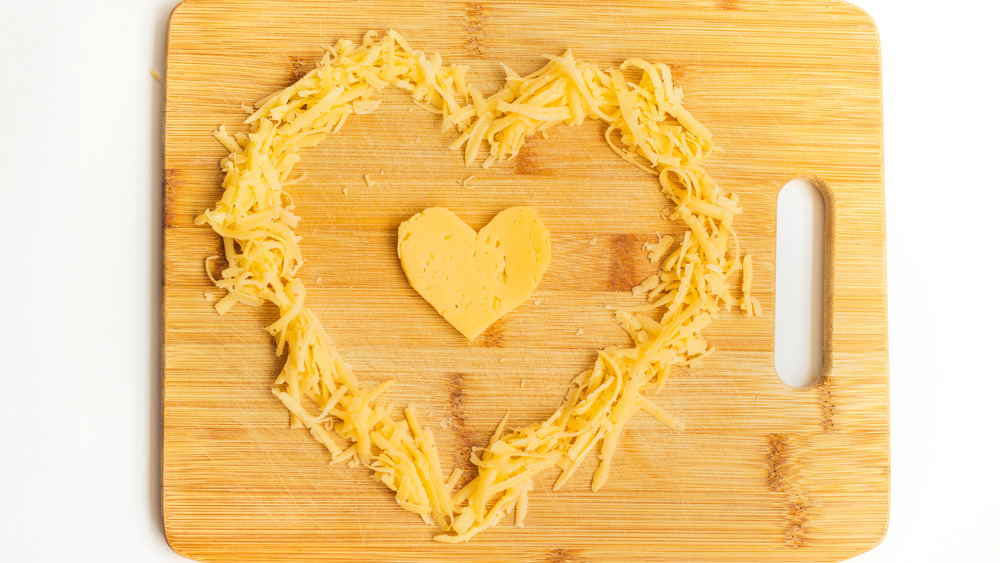 Heart-shaped cheese on cutting board