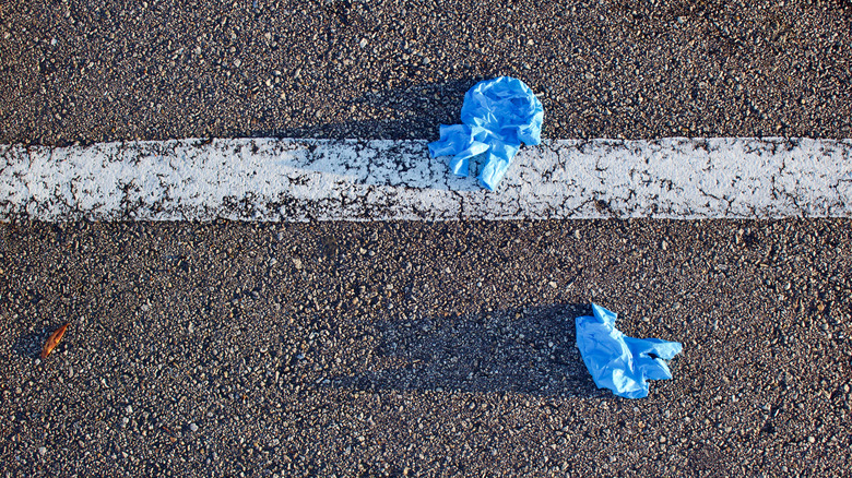 two discarded gloves in parking lot