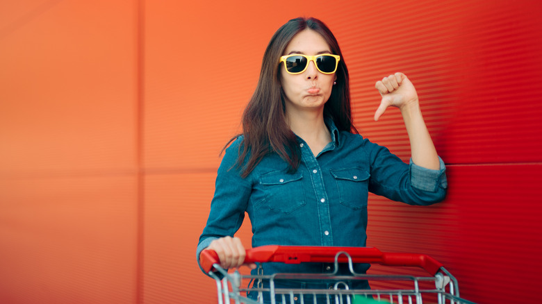 disappointed woman with shopping cart 