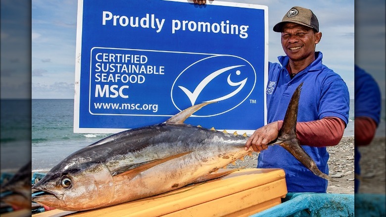 man holding MSC label and fish