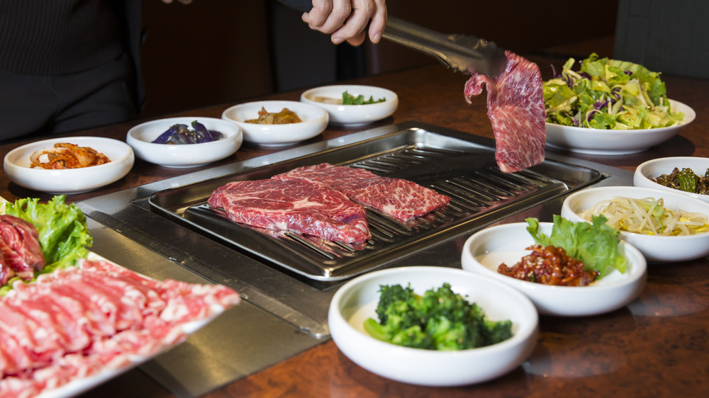 Chef cooking beef for Korean barbecue on table grill