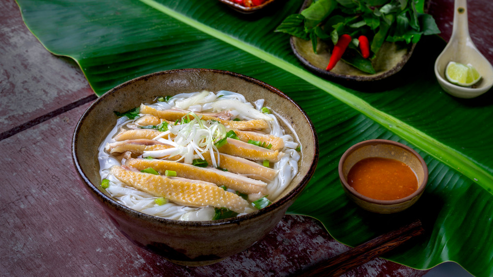 Pho in bowl next to banana leaf