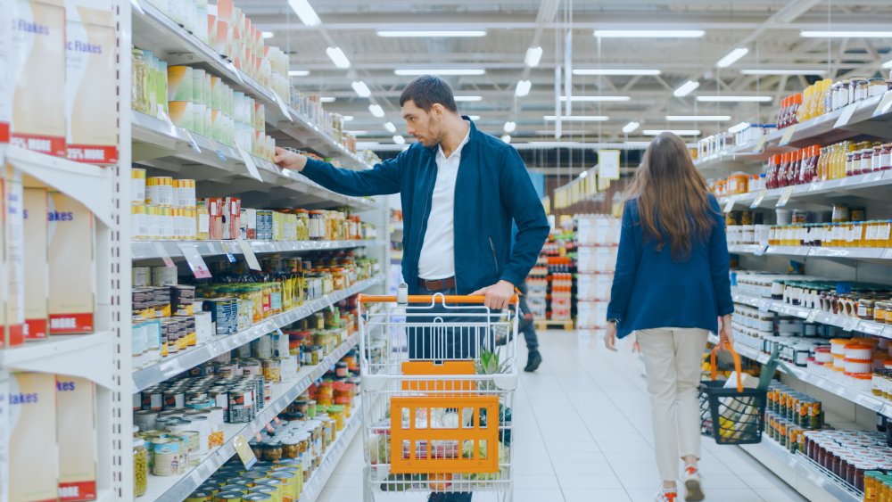 A generic image of a person buying canned food at a supermarket