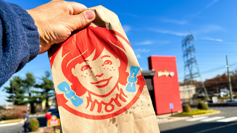 person holding bag of fast food from Wendy's