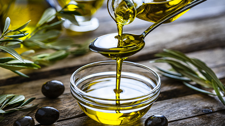 Olive oil poured into spoon and bowl