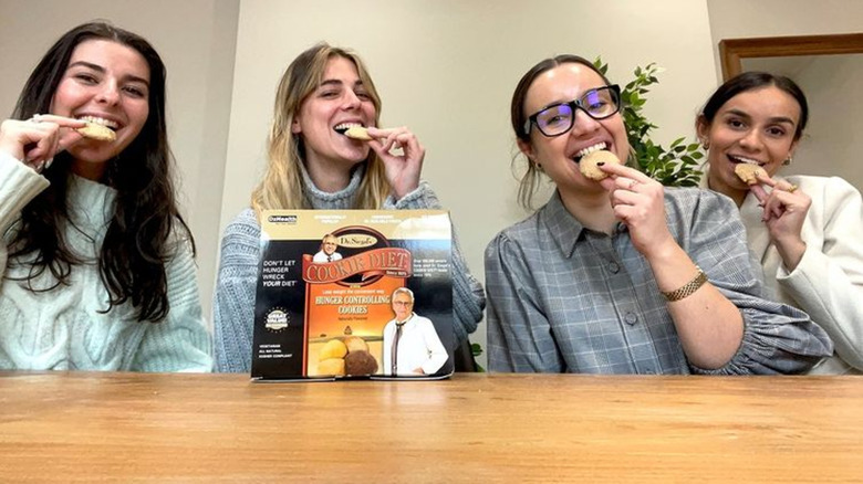 Women eating cookies at table