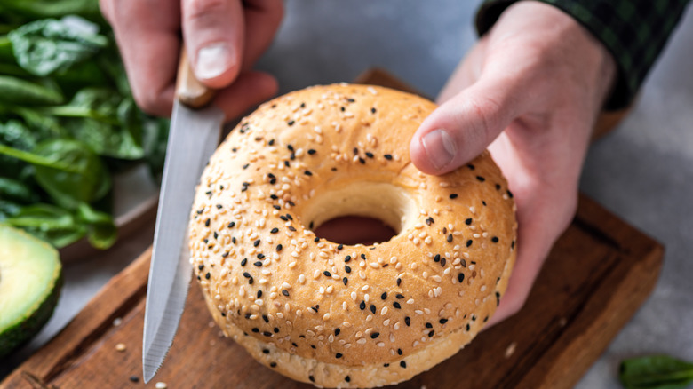 Cutting bagel with knife