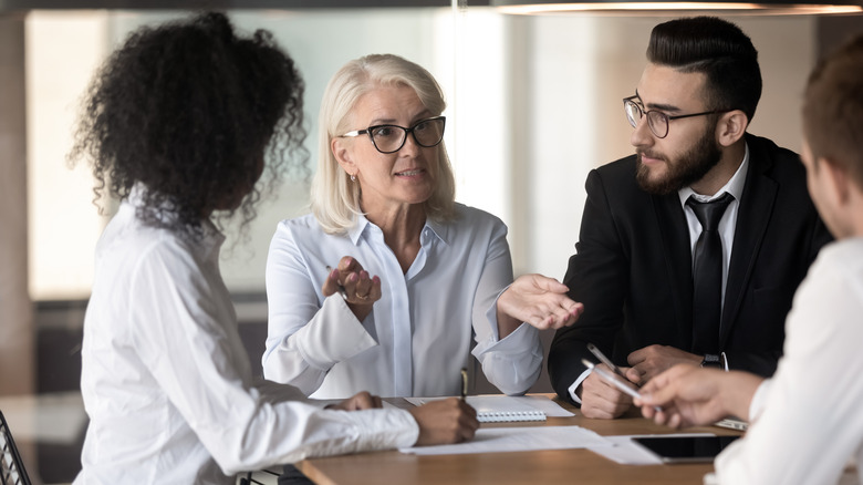 Women talking with others at work