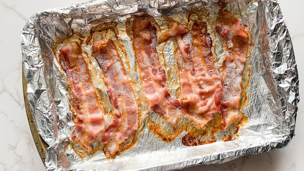 cooked bacon on foil in pan