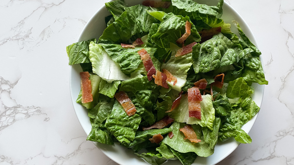 sliced bacon on romaine lettuce in bowl