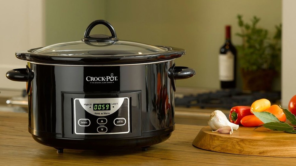 slow cooker with bottle of wine in background