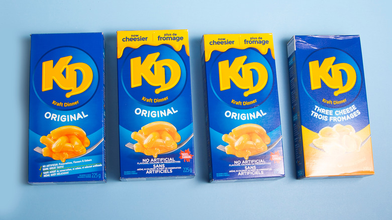 Several boxes and flavors of Kraft Dinner on a blue background