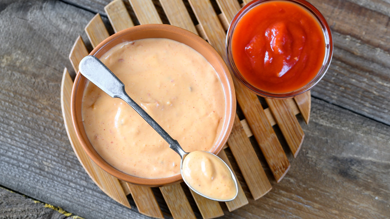 Creamy red sauce with spoon on wooden tablet