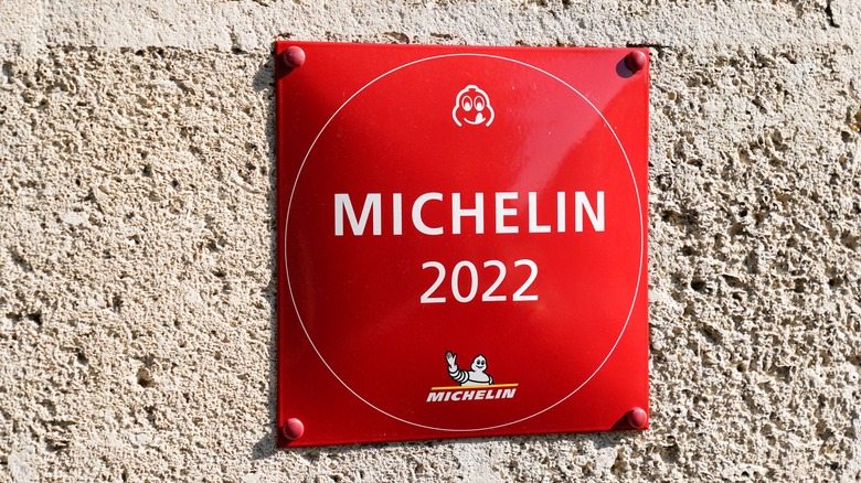 A red Michelin 2022 plaque on a stone wall