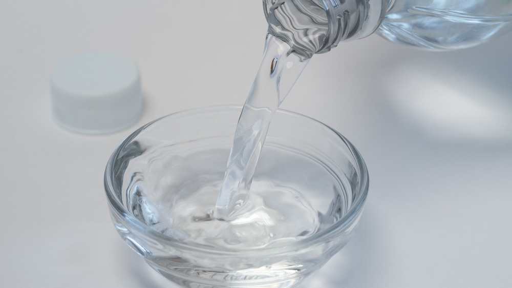 Pouring white vinegar into a bowl