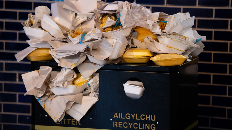 Garbage bin overflowing with takeout containers