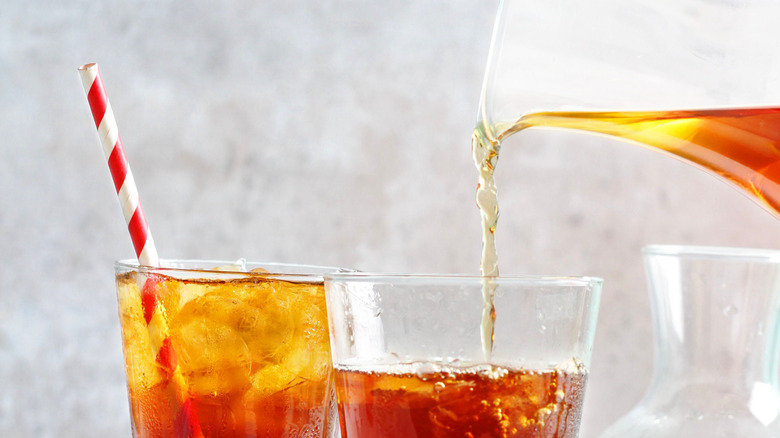 Pouring iced tea into clear glasses