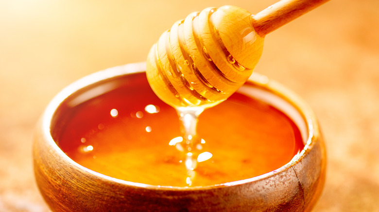 Honey dripping into a bowl