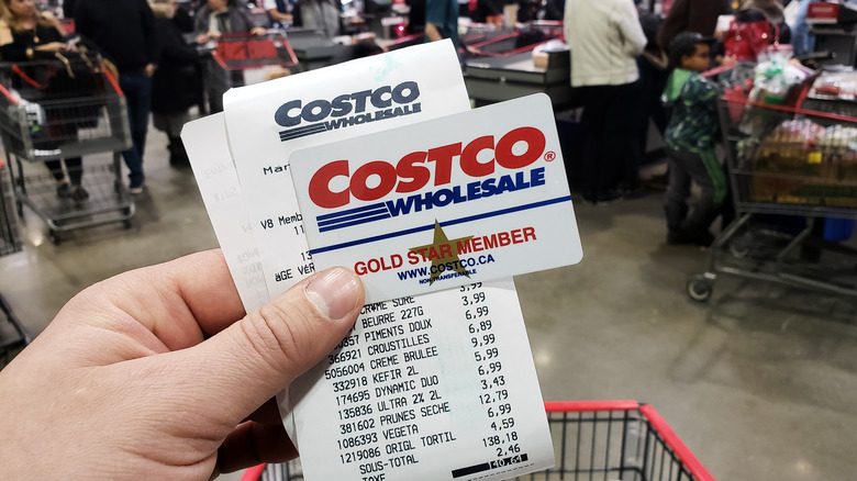 Hand holding a Costco membership card