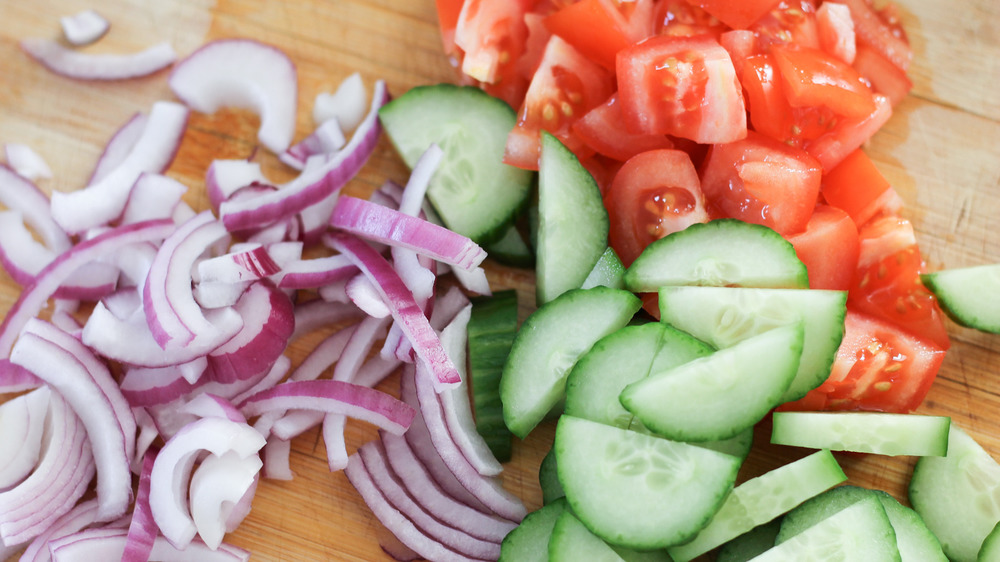 fresh veggies being cut for Greek salad