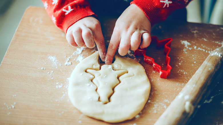 Kid cutting out Christmas cookie