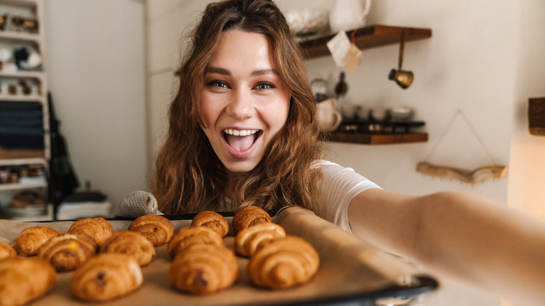 A woman with a tray of fresh baked goods